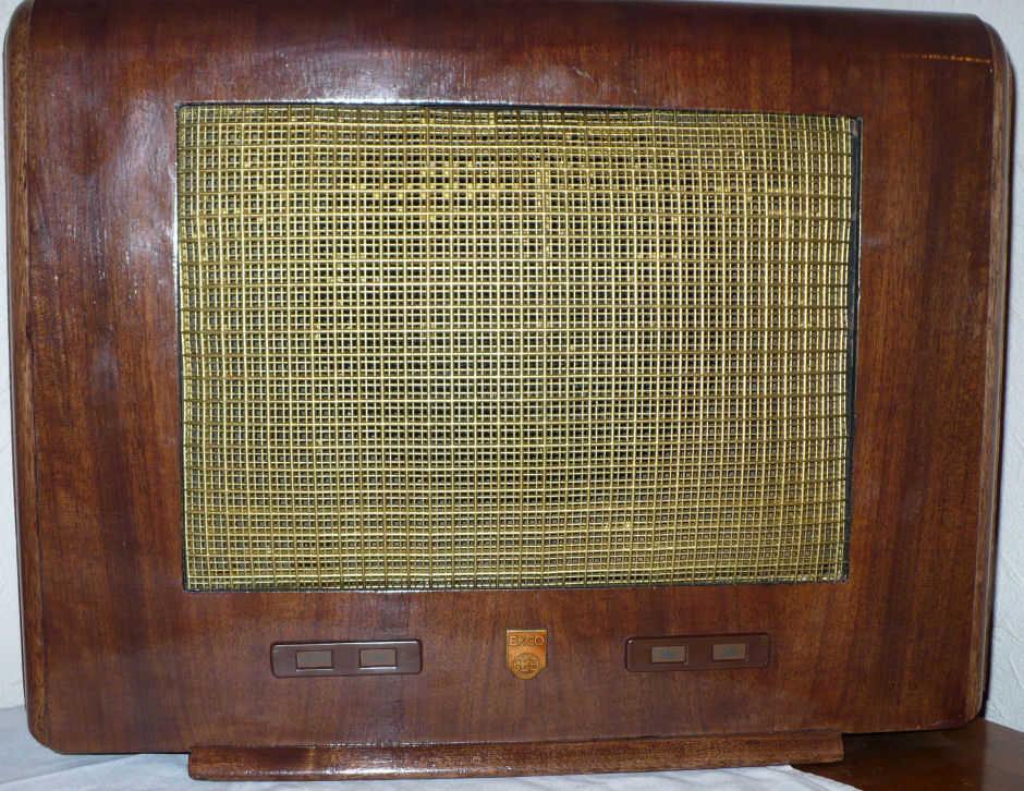 Walnut cabinet with a large brass-coloured wire mesh speaker grille and two small control panels along the bottom